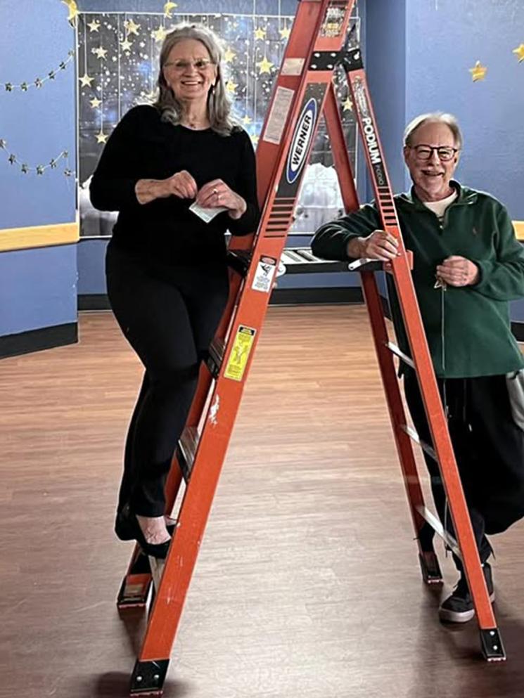Picture of a woman and a man decorating for the prom event