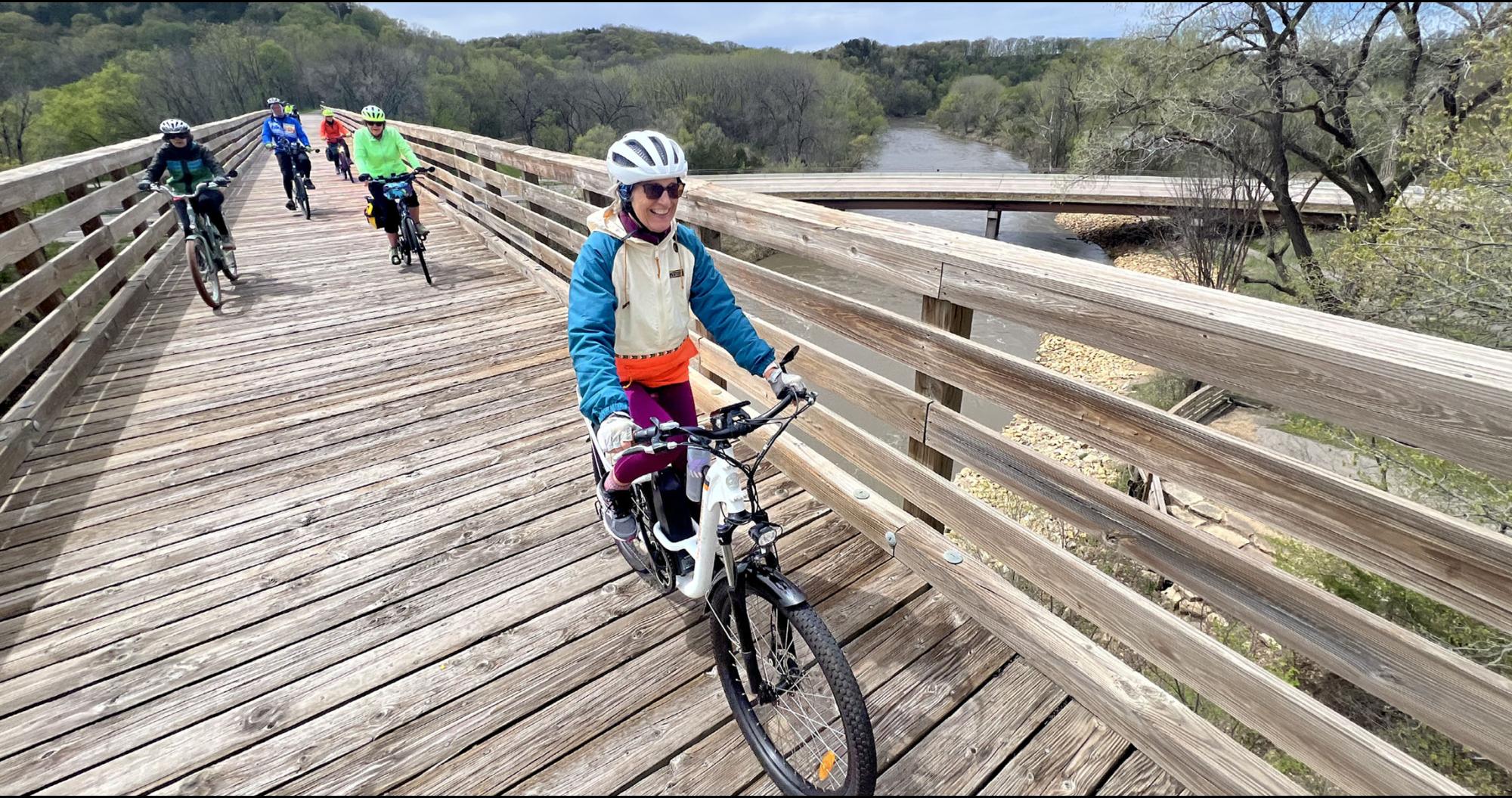 Pedalers crossing a bridge